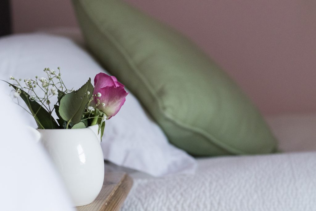 close up image of crisp white linens and decorative plant